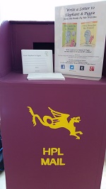 Photo of a child's purple mailbox with hpl mail and a dragon painted on it
