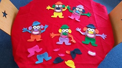 Photo of a table covered in red felt with felt Mr. Potato Head pieces on it
