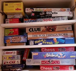 Photo of many different board games in a cabinet