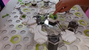 Photo of a child's construction toy and a child's hand playing with the toy