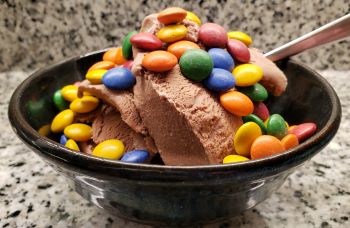 Bowl of chocolate ice cream with chocolate candies on top