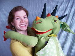 Photo of a woman with a large green dragon puppet