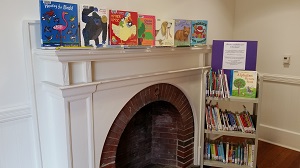 Photo of a fireplace with children's books displayed on the mantle