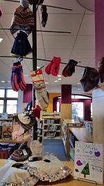 Photo of a wooden tree with several pairs of mittens hung on it