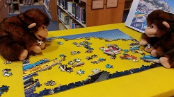 Photo of two monkey puppets working on a jigsaw puzzle
