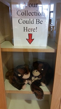 Photo of two monkey puppets in a glass display case