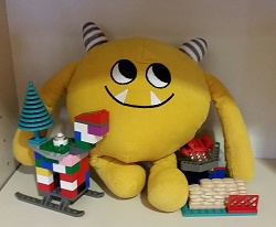 Photo of a yellow stuffed animal monster with legos