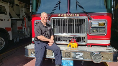 Nibbles and the Fire Chief Yellow stuffed animal monster on a fire truck with fire chief