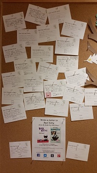 Postcards! Photo of a bulletin board with many postcards pinned to it