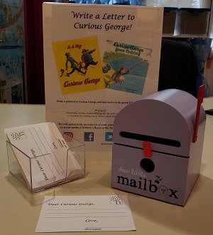 HPL Purple Mailbox Photo of a toy purple mailbox and a box of blank postcards