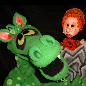 Photo of a green dragon puppet and a prince puppet