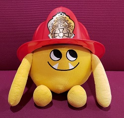 Nibbles in a Firefighter's Helmet Photo of a yellow stuffed animal monster in a firefighter's helmet