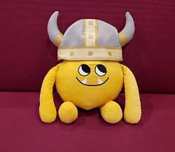 Nibbles in a Viking Helmet Photo of a yellow stuffed animal monster in a Viking helmet