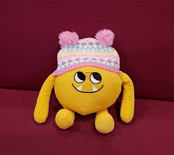 Nibbles in a Winter Hat Photo of a yellow stuffed animal monster wearing a winter hat