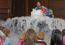 Photo of a man in a tie-dyed shirt standing behind a table that has steam flowing out over it