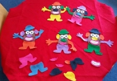 Photo of a table covered in red felt with felt Mr. Potato Head pieces on it
