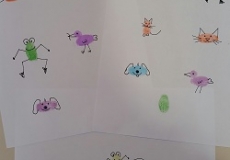 Photo of a child's drawings made with multicolored fingerprints