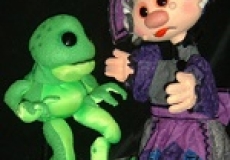 Photo of two puppets a green frog and a woman in a purple dress
