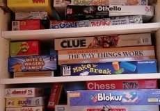 Photo of many different board games in a cabinet