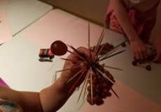 Photo of a child's hand holding grapes that have toothpicks stuck into them