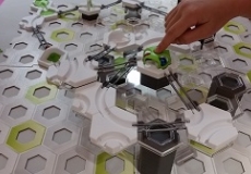 GraviTrax Challenge Photo of a child's construction toy and a child's hand playing with the toy