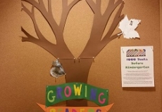 Photo of a bulletin board with a construction paper tree and leaves and the words Growing Readers