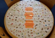 Photo of a child's table covered with a piece of paper and stickers