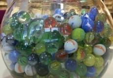 How many marbles in the fishbowl? Photo of a glass fishbowl filled with marbles