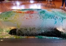 Photo of a large chunk of ice colored with many colors of food coloring