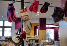 Photo of a wooden tree with several pairs of mittens hung on it
