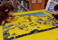 Photo of two monkey puppets working on a jigsaw puzzle