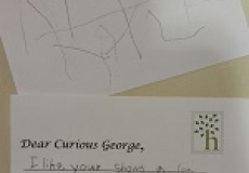 Photo of two postcards written by a child to curious george