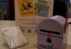 HPL Purple Mailbox Photo of a toy purple mailbox and a box of blank postcards