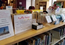 Photo of a sign that says raffle items and several plastic boxes